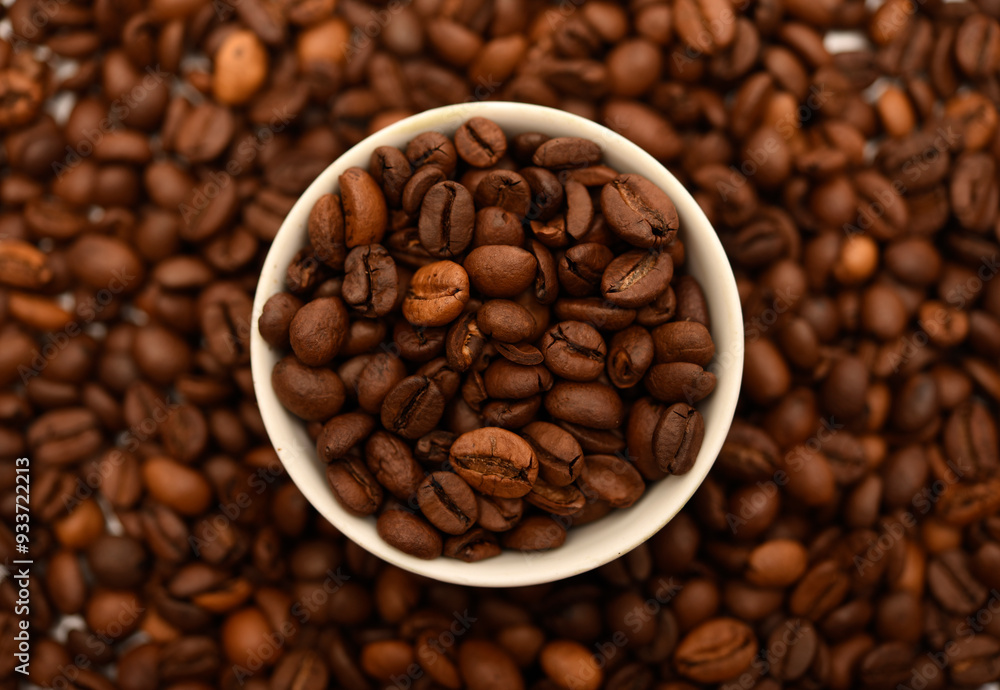 A bowl with coffee beans on the background of coffee beans. A bowl with coffee beans on the background of coffee beans.