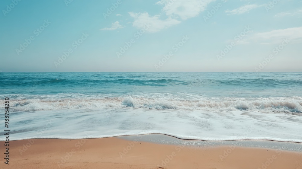 A serene beach with light blue waves gently lapping at the shore under a clear sky A serene beach with light blue waves gently lapping at the shore under a clear sky