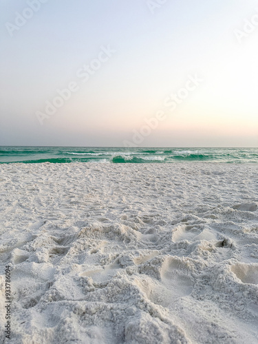 Close up of white sand beach with coast and sky.