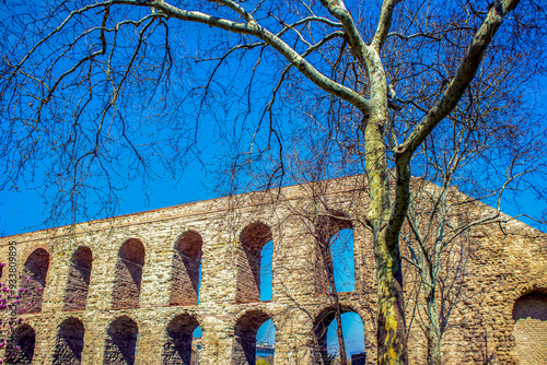 Aqueduct of valens (bozdogan kemeri) of Roman empire and tree under blue sky, constantinople, unkapani istanbul photo