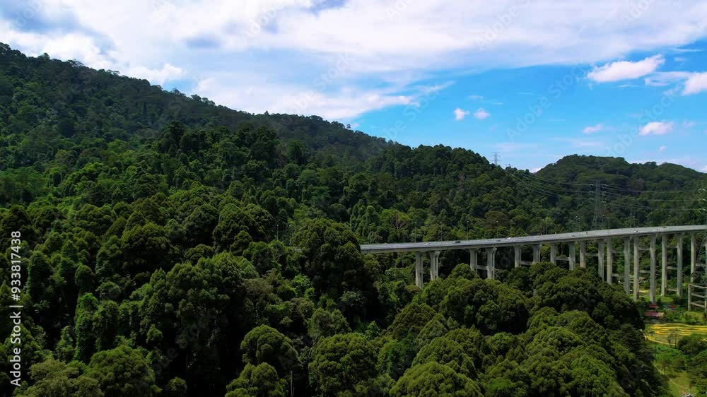 Aerial view of the Tree Giam Kanching bypass highway winding through the mountains of Rawang, Selangor, Malaysia surrounded by greenery. Aerial view of the Tree Giam Kanching bypass highway winding through the mountains of Rawang, Selangor, Malaysia surrounded by greenery.