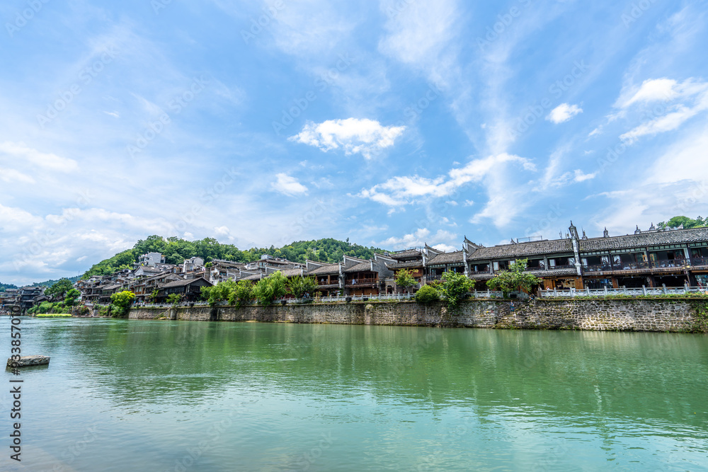 Fototapeta premium Green Water and Traditional Miao Village Architecture by the River in Fenghuang Ancient Town, Xiangxi, Hunan