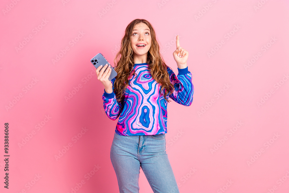 Portrait of nice young girl smart phone direct finger up empty space wear sweater isolated on pink color background Portrait of nice young girl smart phone direct finger up empty space wear sweater isolated on pink color background