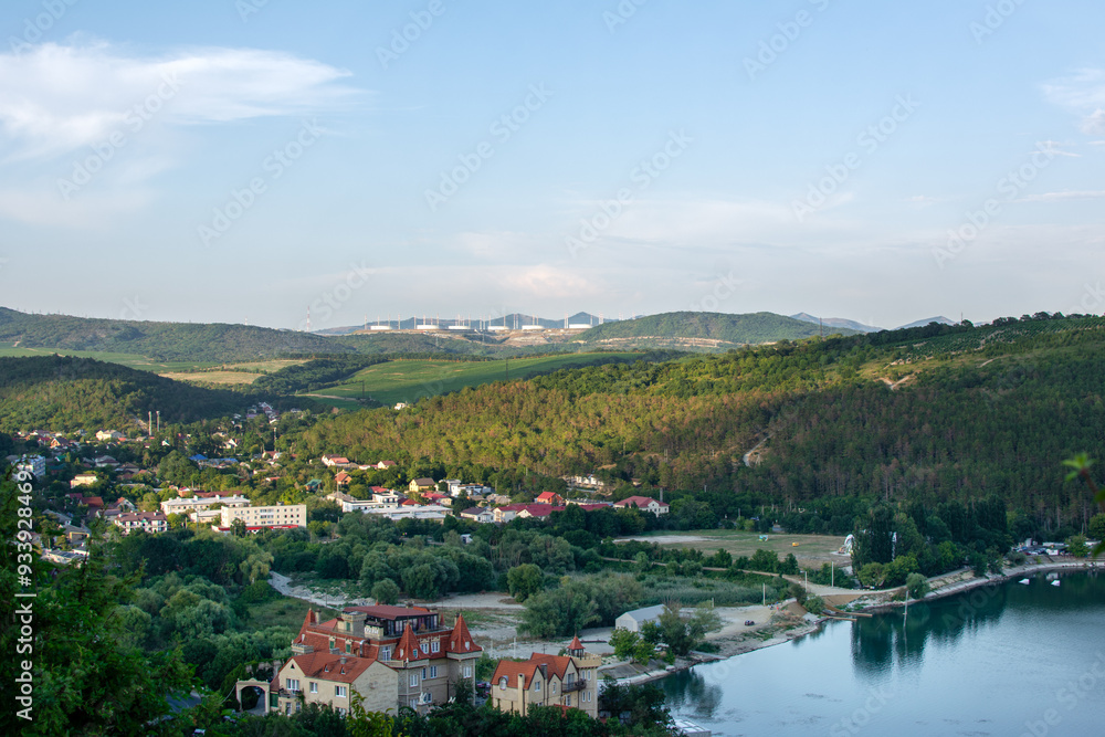 Stunning scenic views of the mountain landscape, complemented by a serene pond and houses on the hills Stunning scenic views of the mountain landscape, complemented by a serene pond and houses on the hills