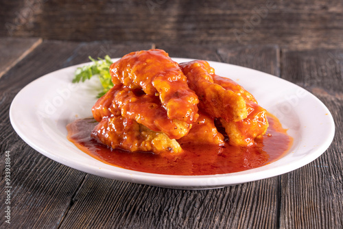 fried fish in sweet and sour sauce on wood table. Chinese food. food concept.