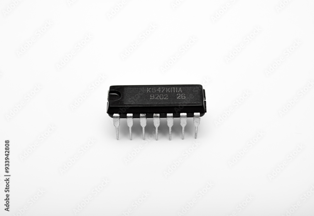 An old chip on a white background. The chip is in a DIP case. An integrated circuit. An old chip on a white background. The chip is in a DIP case. An integrated circuit.