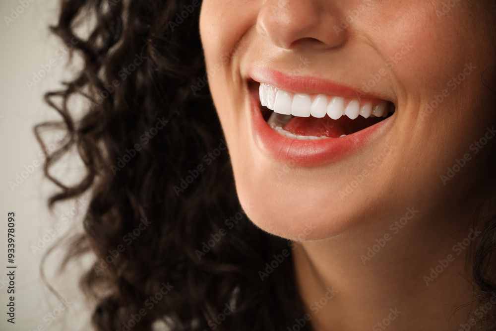 Smiling woman on light grey background, closeup. Dental veneers Smiling woman on light grey background, closeup. Dental veneers
