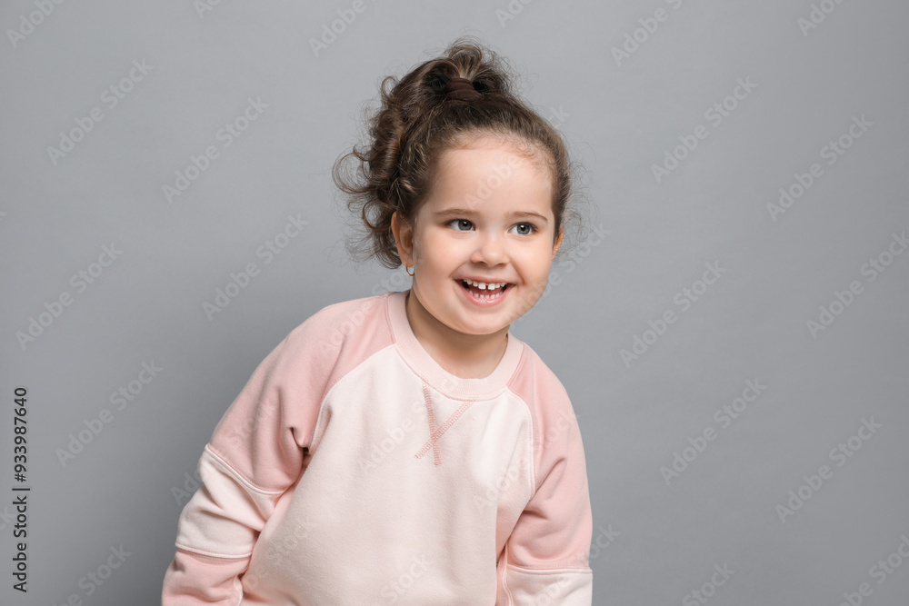 Adorable child. Portrait of happy girl on grey background. Space for text Adorable child. Portrait of happy girl on grey background. Space for text