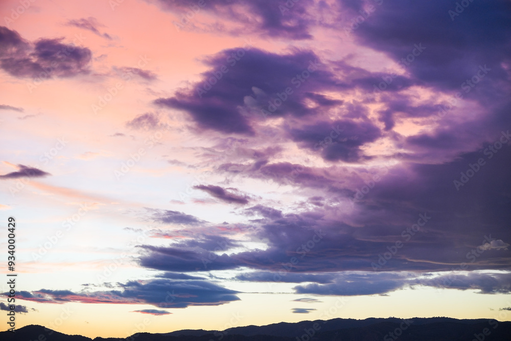 Fototapeta premium The sky is filled with clouds and the sun is setting