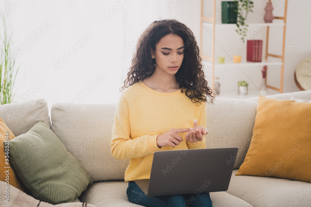 Photo portrait of wavy hair young girl sitting and studying from home using her laptop learning count maths indoors living room apartment Photo portrait of wavy hair young girl sitting and studying from home using her laptop learning count maths indoors living room apartment
