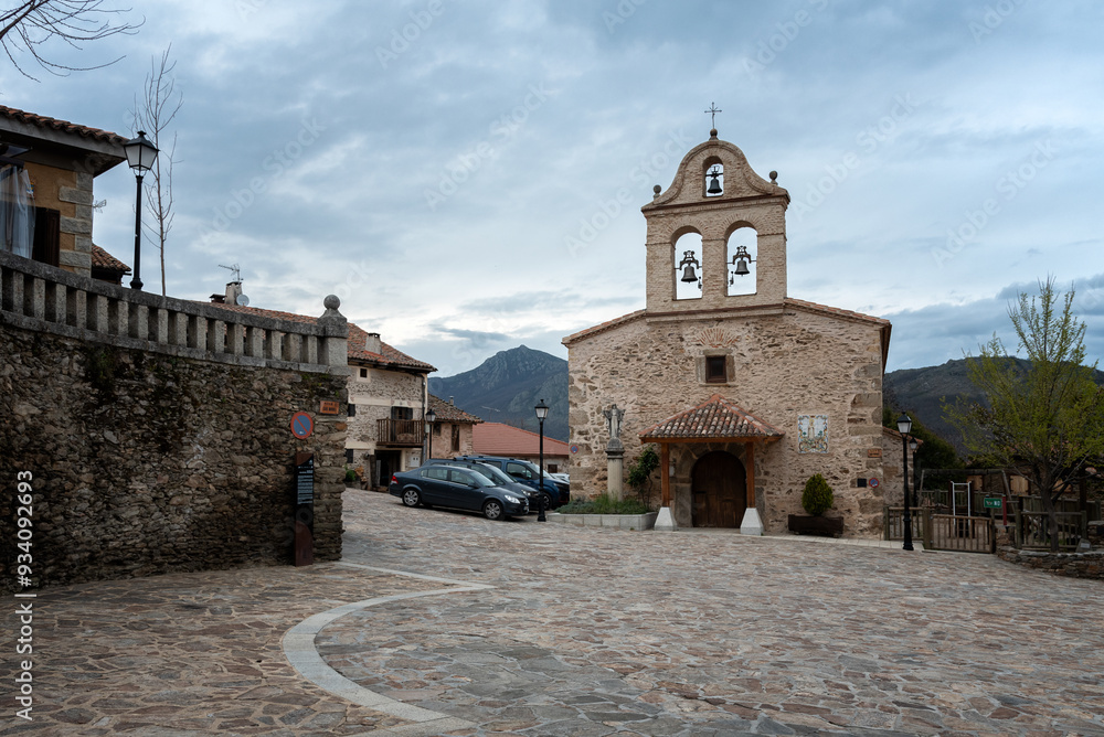 Φωτογραφία Street of the picturesque village of La Hiruela with the small church of Saint Michael the Archangel with its bell tower on a cloudy day, Madrid, Spain