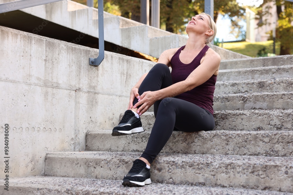 Woman suffering from foot pain on steps Woman suffering from foot pain on steps