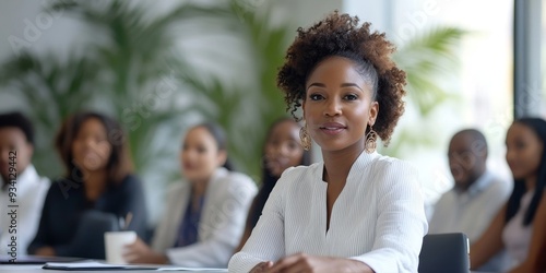 Young business people sitting around big table and listening to team leader. Black woman standing in modern white office boardroom during meeting and speaking to group of multiracial, Generative AI
