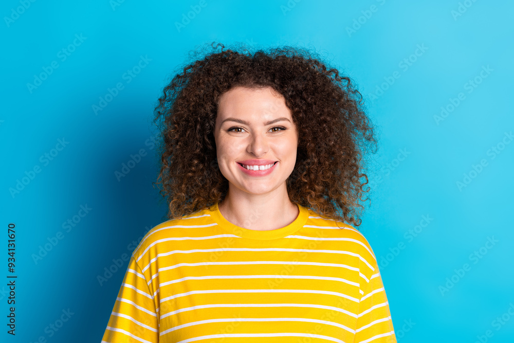 Photo portrait of attractive young woman look camera smile dressed stylish striped yellow clothes isolated on blue color background Photo portrait of attractive young woman look camera smile dressed stylish striped yellow clothes isolated on blue color background