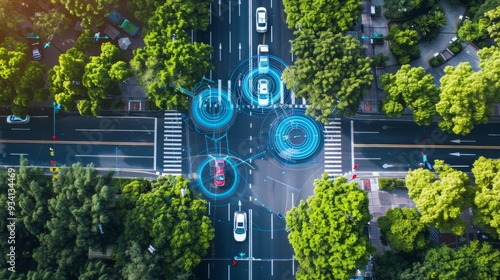 Fototapeta Naklejka Na Ścianę i Meble -  Aerial view of autonomous cars navigating a city intersection, highlighted by digital overlays illustrating advanced driving technology and connectivity
