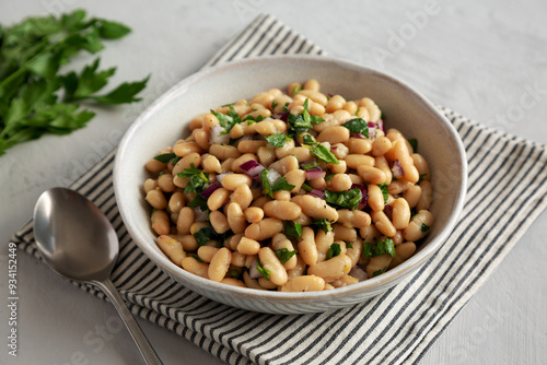 Homemade White Bean Salad with Herbs and Onion in a Bowl, side view.