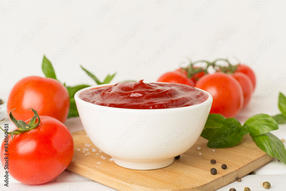 Delicious ketchup with spices and tomatoes on wooden table Delicious ketchup with spices and tomatoes on wooden table