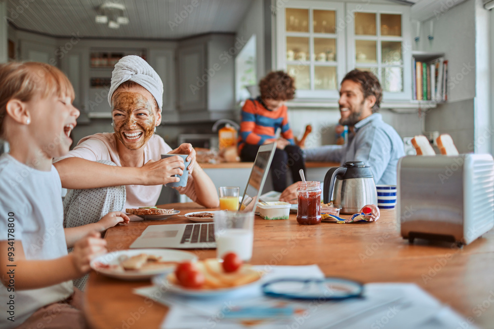 Happy family enjoying breakfast together in modern kitchen with laptop Happy family enjoying breakfast together in modern kitchen with laptop
