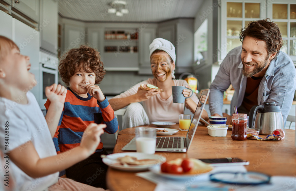 Happy family enjoying breakfast together in modern kitchen with laptop Happy family enjoying breakfast together in modern kitchen with laptop