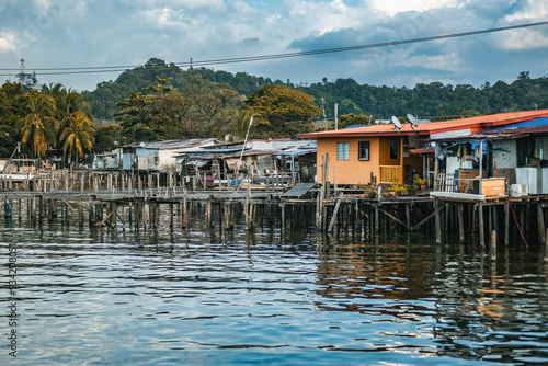 Fishing village houses over the water garbage poor areas in Sabah province in Malaysia photo