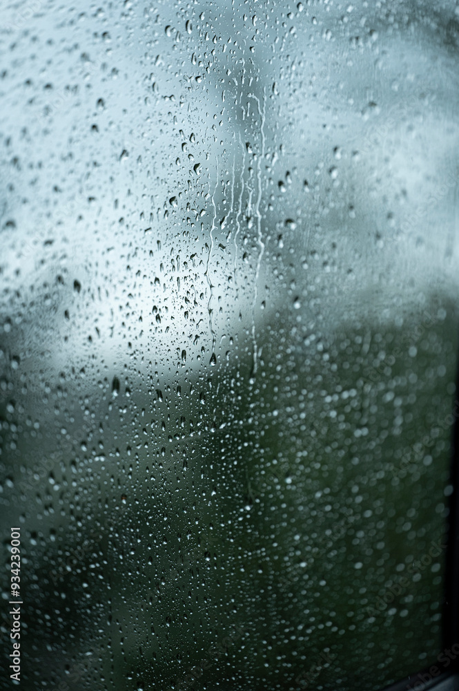 Obraz premium view through the raindrop window on rainy day in vertical