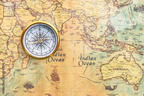 Classic round compass on background of old vintage map