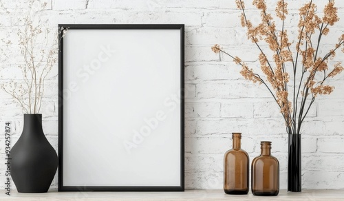 Minimalist interior decor with empty frame and dried flowers on a wooden table