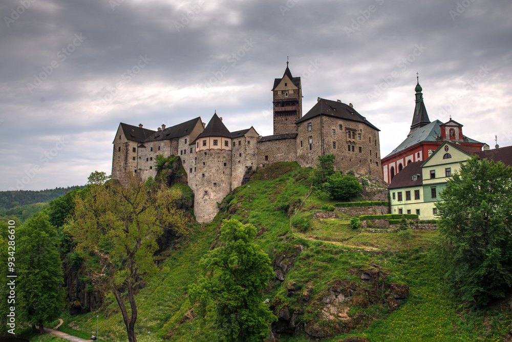 Medieval Loket Castle in the Czech Republic in summer under a cloudy sky. Medieval Loket Castle in the Czech Republic in summer under a cloudy sky.
