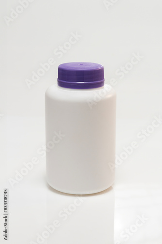 white plastic bottle with purple lid on white background