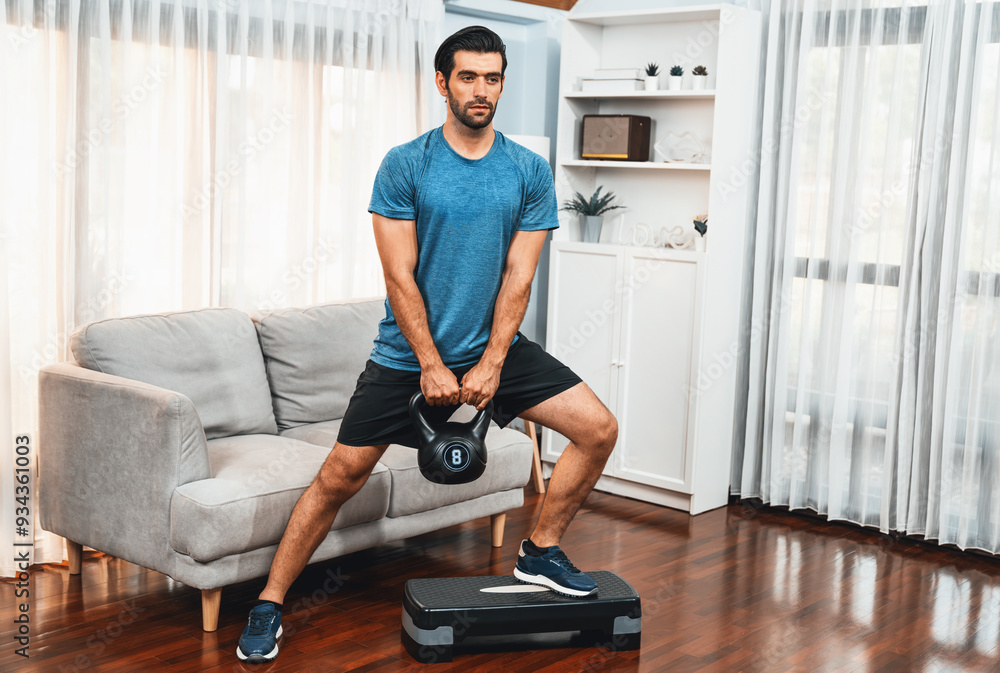 Athletic body and active sporty man doing squat with kettlebell weight for effective targeting muscle gain at gaiety home as concept of healthy fit body home workout lifestyle. Athletic body and active sporty man doing squat with kettlebell weight for effective targeting muscle gain at gaiety home as concept of healthy fit body home workout lifestyle.