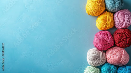 colorful yarn balls for knitting on blue background with copy space