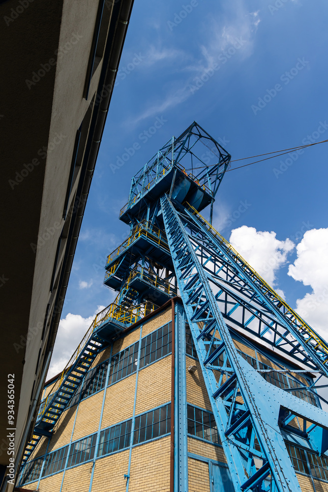 Blue coal mine shaft against a blue sky with delicate clouds. Reduction of fossil fuel extraction in favor of renewable fuels