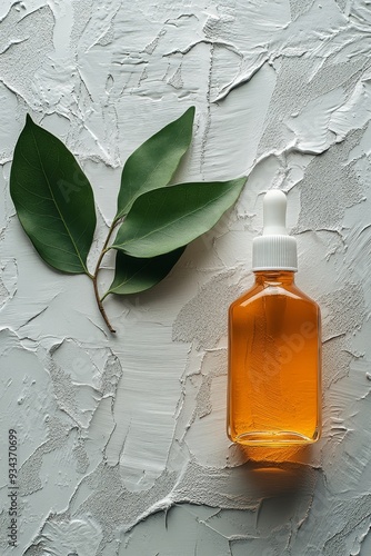 Botanical drops on textured surface with green leaves and liquid container