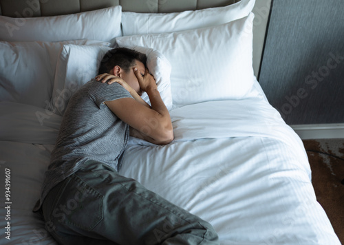 lonely sad depressed man lying in be at home alone 