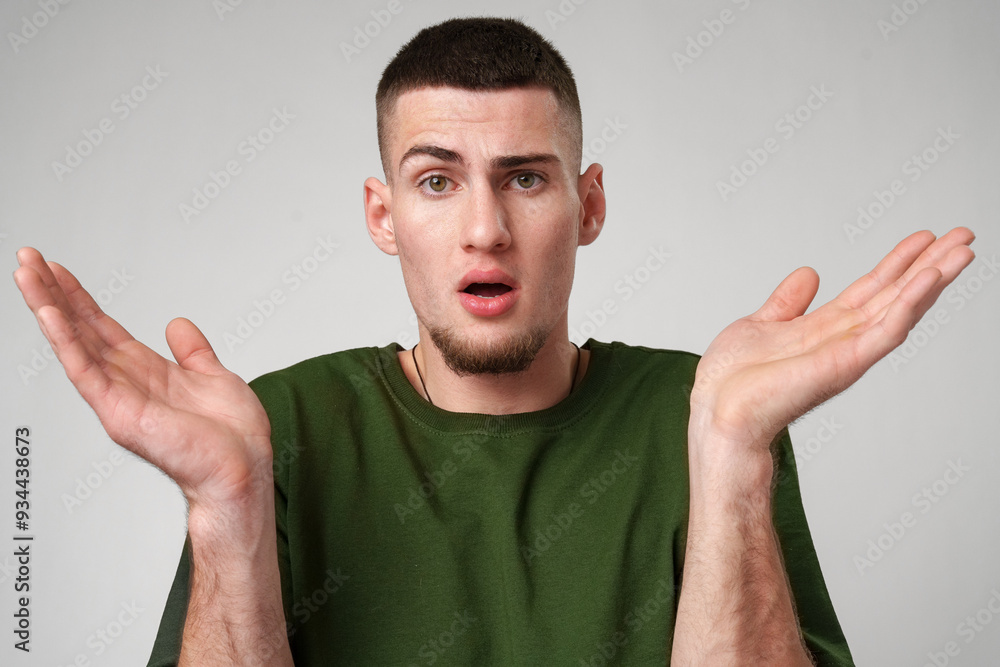 Young Man Looking Surprised Against a Gray Background Young Man Looking Surprised Against a Gray Background