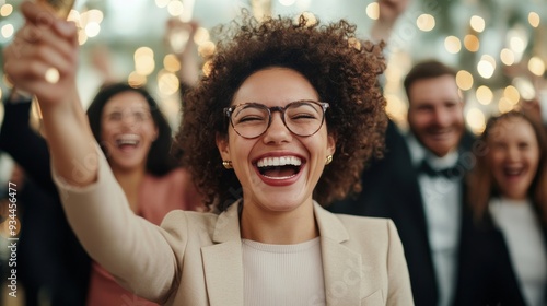 Joyful woman celebrating with friends at a festive party, raising a glass in cheer.