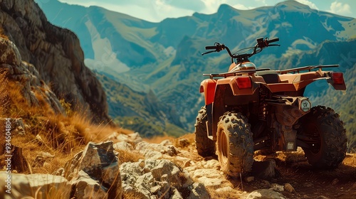 A red ATV is parked on a rocky mountainside with a view of a valley in the background.