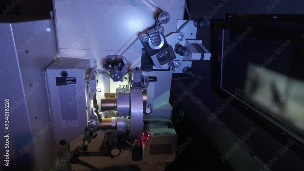 35mm Film running through a cinema projector in a movie theater during a performance- Classic film projector in a cinema. 35mm Film running through a cinema projector in a movie theater during a performance- Classic film projector in a cinema.