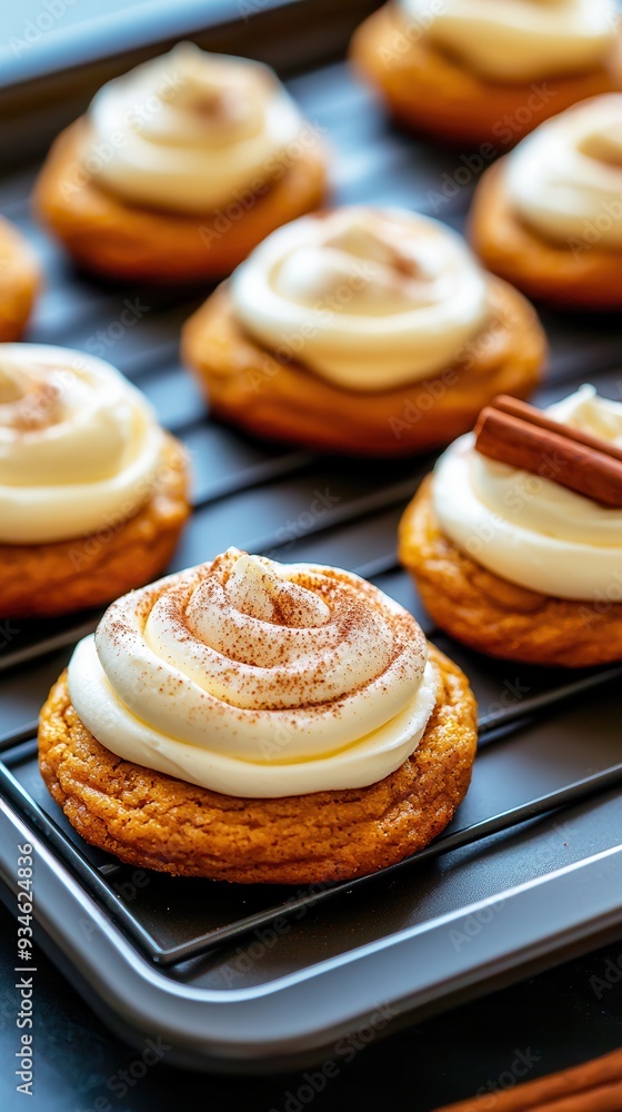 Freshly made pumpkin cookies, covered in a smooth cream cheese frosting and sprinkled with cinnamon, arranged on a baking sheet.
Freshly made pumpkin cookies, covered in a smooth cream cheese frosting and sprinkled with cinnamon, arranged on a baking sheet.