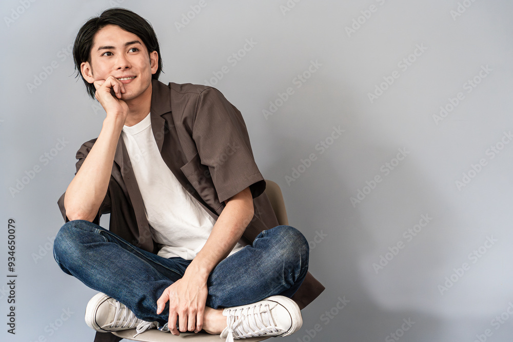 椅子に座るスニーカーとジーンズ姿のさわやかな男性
椅子に座るスニーカーとジーンズ姿のさわやかな男性