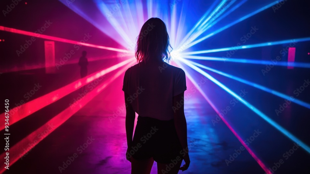 Silhouette of a Person Standing in Front of Vibrant Red and Blue Laser Lights in a Dark Room Silhouette of a Person Standing in Front of Vibrant Red and Blue Laser Lights in a Dark Room