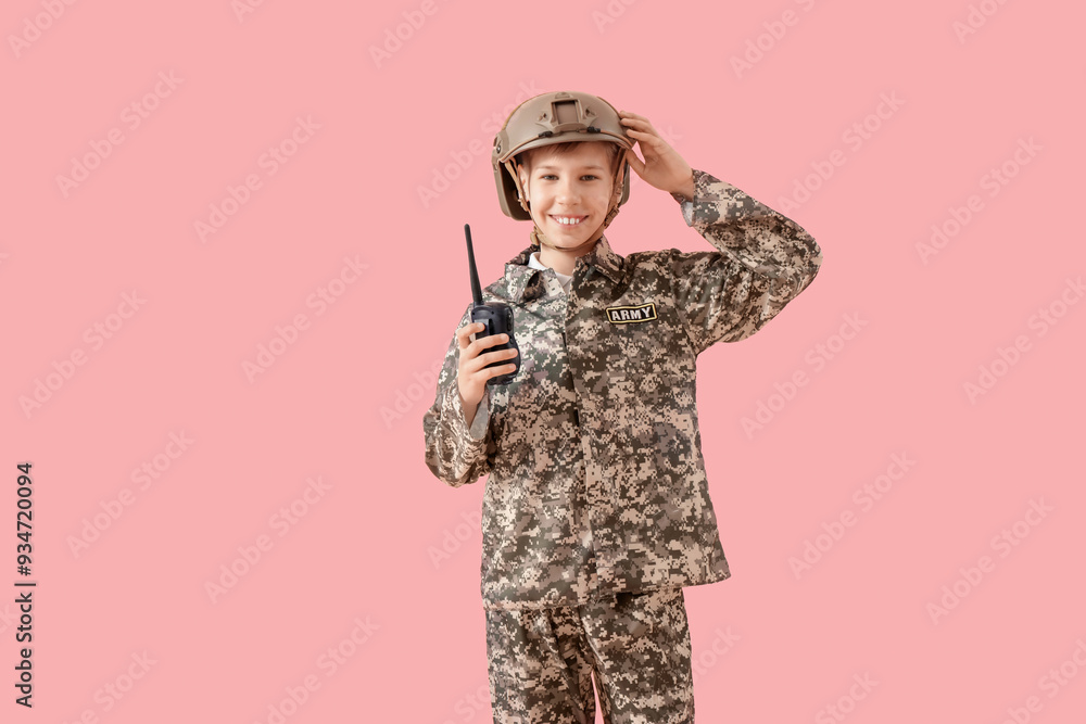 Fototapeta premium Teenage soldier with walkie-talkie on pink background