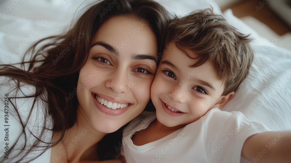 Mother and son enjoy a joyful moment together indoors during the morning hours, smiling and embracing each other Mother and son enjoy a joyful moment together indoors during the morning hours, smiling and embracing each other