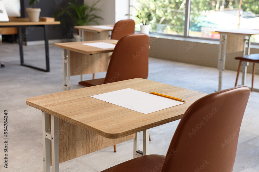 School desks with sheet of paper and pencil prepared for exam. Closeup School desks with sheet of paper and pencil prepared for exam. Closeup