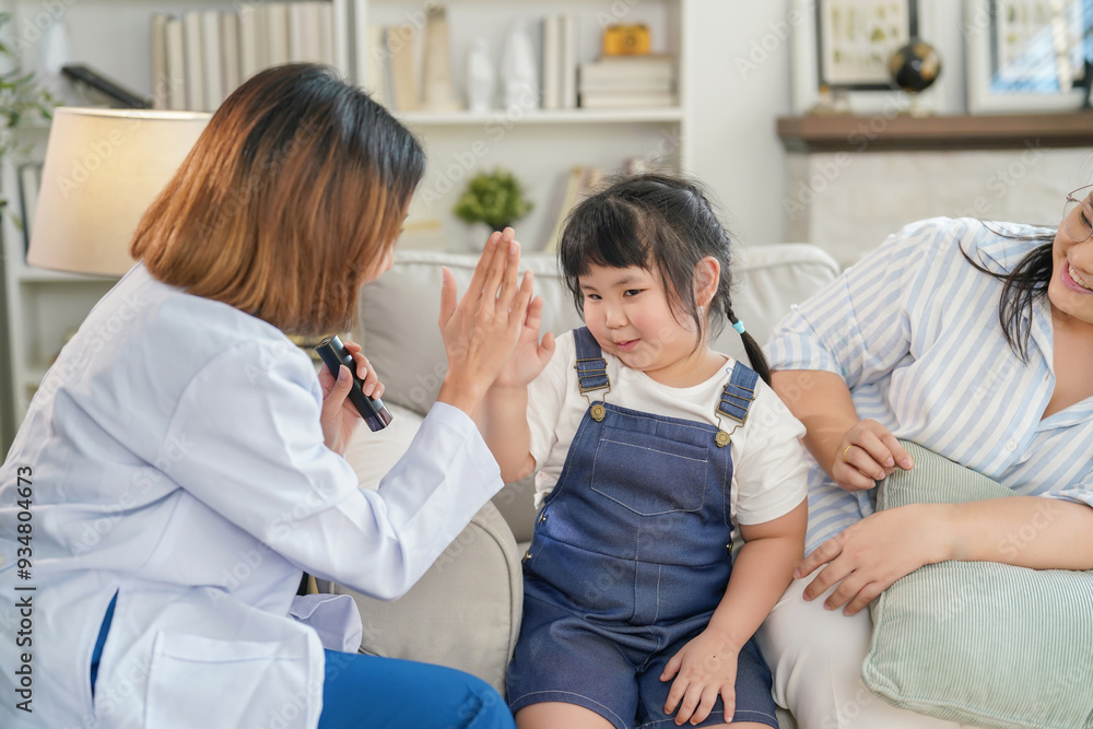 Fototapeta premium happy adorable asian child girl giving high five with young female doctor in examining room at dental clinic,a little kid being encouraged by dentist