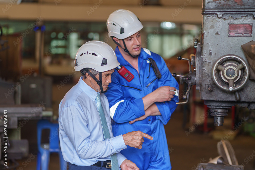 an experienced manager and a young caucasian technician are annual audit inspecting machinery in the factory for maintenance an experienced manager and a young caucasian technician are annual audit inspecting machinery in the factory for maintenance