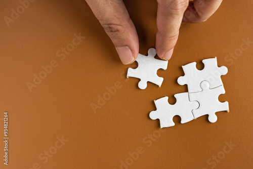 Hand holding puzzle pieces, completing jigsaw puzzle. business concept. Selective focus.