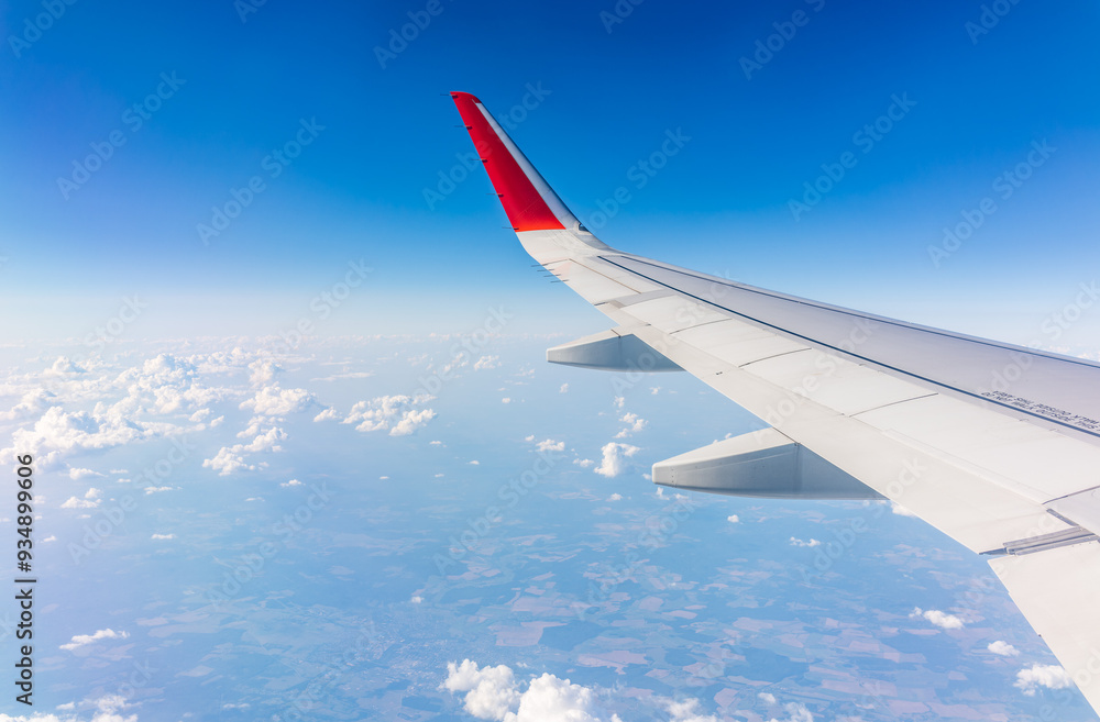 View from the airplane window at a beautiful cloudy sky and the airplane wing View from the airplane window at a beautiful cloudy sky and the airplane wing
