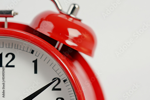 A red alarm clock with a white face showing the time as 10:30. The clock is set to go off at 10:35 photo