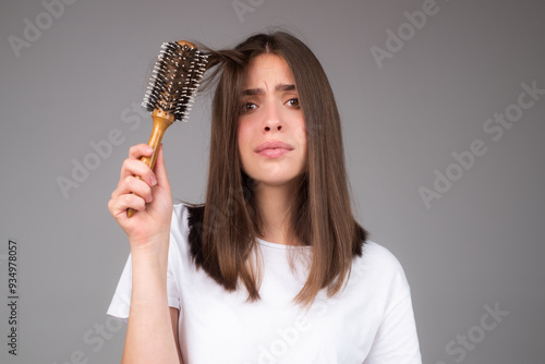 Sad woman with hair loss problem worried about hairloss. Messy bed hair. Problem with tangled hair. Worried girl with damaged hair. Hairloss problem. Portrait of woman with a comb and bad hairs.